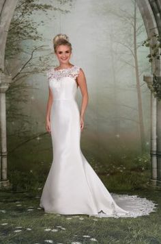 a woman in a white wedding dress standing in front of an arch with flowers on it