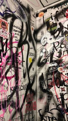 the wall is covered in graffiti and has many different types of writing all over it