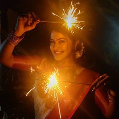 a woman is holding sparklers in her hand