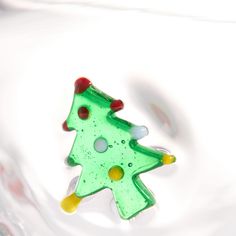 a glass christmas tree ornament sitting on top of a table