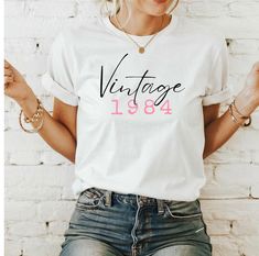 Unique vintage birthday shirts - personalized for your party Celebrate your special day with a unique, personalized vintage birthday shirt! Our lovingly designed shirt combines nostalgic charm with modern comfort. Each shirt is customized for you, with your name and year of birth to add a personal and meaningful touch. Enjoy high-quality materials and a timeless design that is perfect for any birthday celebration. A great gift for friends, family or for yourself - make your birthday unforgettabl Vintage White T-shirt For Birthday, Retro White Tops For Anniversary, Vintage Letter Print Tops For Anniversary, Retro White Top For Birthday, Vintage White Top For Birthday, Vintage White T-shirt As Gift, Vintage Crew Neck Top As Gift, Vintage Short Sleeve Tops For Birthday, Vintage Short Sleeve Tops For Gift