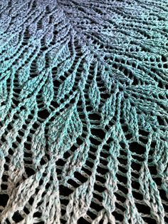 a close up view of a knitted blanket with wavy lines on the top and bottom