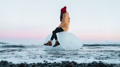 a person sitting on an iceberg in the water