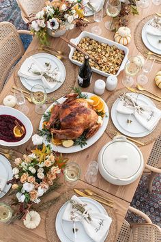 a table set for thanksgiving dinner with turkey, oranges and cranberry sauce