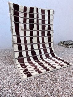 a brown and white blanket sitting on top of gravel