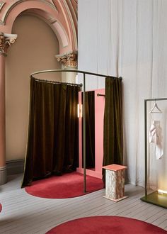 a room with pink walls and red rugs on the floor next to a mirror