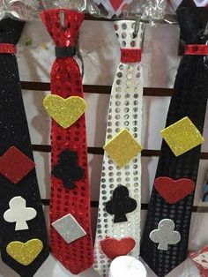 four different types of ties are hanging on a wall with sequins and hearts