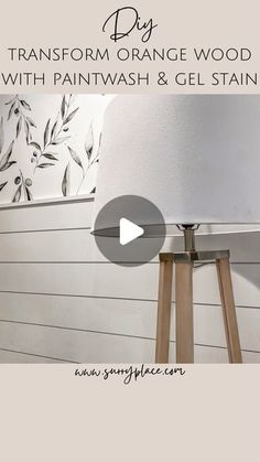 a lamp that is sitting on top of a wooden tripod next to a wall