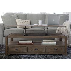 a living room with a couch, coffee table and laptop on top of the sofa