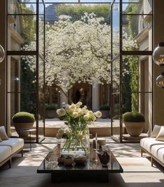 a living room filled with lots of furniture and flowers on top of a coffee table