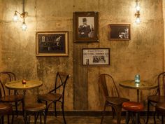 the interior of a restaurant with wooden tables and chairs, framed pictures on the wall