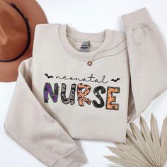 Embrace the spooky season with our trendy Comfort Colors® Halloween Neonatal NICU Nurse Sweatshirt, the perfect Spooky Nicu Nurse Costume and Nursing Crewneck. Ideal as a Pediatric Nurse Gift, this Halloween Nurse Sweater blends style and comfort for a hauntingly fun team celebration for the baby nurse. UNISEX SIZING, relaxed fit. Not a Women's size, please refer to the size chart for more details. HOW TO ORDER: 1. Review all photos. 2. Select size and color from drop down menu.  3. Add to cart, Novelty Letter Print Tops For Fall, Halloween Cotton Sweatshirt With Character Print, Customizable Cute Tops For Fall, Cute Halloween Sweatshirt With Letter Print, Cute Cotton Halloween Sweatshirt, Nursing Crewneck, Team Celebration, Nurse Sweater, Mother Baby Nurse