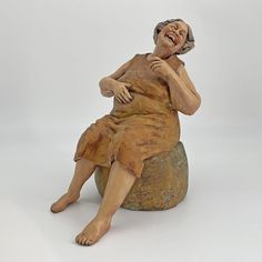 a statue of a woman sitting on top of a rock