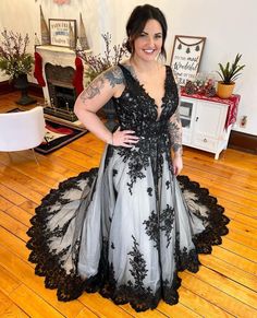 a woman in a black and white dress standing on a wooden floor with her hands on her hips