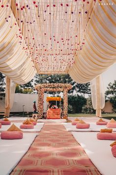 an outdoor ceremony setup with pink and white decorations on the aisle, decorated with flowers