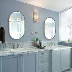 a bathroom with two sinks and three mirrors