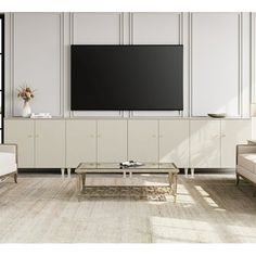 a living room with white furniture and a flat screen tv mounted on the wall above it