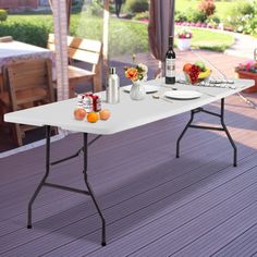 a white table sitting on top of a wooden floor next to a patio covered in furniture