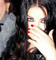 a woman with red nails covering her face