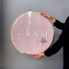 a woman holding up a sign that says the glam factor on it's side