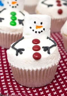 some cupcakes with frosting and decorations on them are sitting on a table