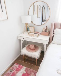 a white desk with a pink hat on top of it and a mirror in the corner