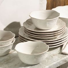 a stack of white dishes sitting on top of a table