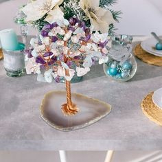 a centerpiece with flowers on a table at a wedding or other function in the dining room