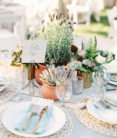 a table set with place settings and flowers