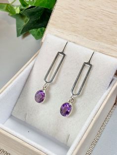 "Sparkly dazzlers of bright purple! These Amethyst earrings are stunning. The open back of their bezel setting allows light to shine through the gemstones and show off their brilliant purple color! All Sterling setting and ear wire. These earrings hang 2 inches and are lightweight and comfortable. These high quality Amethyst gems are faceted and have a lovely color and shine. Mid-century vibe gives all the feels! Comes in a standard gift box and is perfect for a February born gift recipient sinc Modern Purple Gemstone Earrings, Modern Purple Dangle Jewelry, Everyday Purple Amethyst Earrings, Purple Gemstone Earrings For Everyday Wear, Everyday Purple Gemstone Earrings, Purple Modern Sterling Silver Earrings, Modern Purple Sterling Silver Earrings, Modern Amethyst Earrings As Gift, February Born