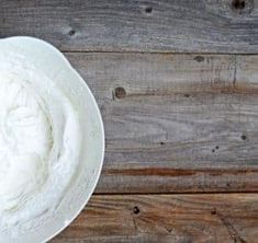 a white plate topped with whipped cream on top of a wooden table