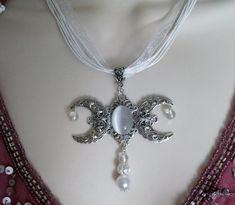 "This beautiful necklace has a sterling silver plated filigree triple moon pendant with a catseye setting, pearl bead, clear Czech glass beads, sterling silver plated filigree bead, sterling silver plated bead cap and a beautiful white organza ribbon. 18\" long. Lobster clasp." Jewelry Witchcraft, Moon Goddess Necklace, Wicca Jewelry, Pagan Necklace, Wiccan Necklace, Triple Moon Goddess, New Plymouth, Goddess Jewelry, Wiccan Jewelry