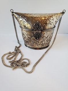 "This OOAK gorgeous vintage silver toned metal purse is the perfect next addition to your purse collection! This stunning unique bag is made of silver tone brass and has fabulous embossing motif, a long chain strap and ornate hinged clasp. The lining on the inside is a black velvet. This vintage metal purse is perfect for both casual and formal outfits alike. Get this amazing purse for yourself or for someone in your life who loves vintage accessories! Excellent vintage condition Height 5\" Width 6\" on top, 3.75\" on bottom Length 3\" Opening 4\" x 3\" 44\" chain US SHIPPING FREE  International shipping, please see the rate  Please add our shop as a ❤ favorite so you can find us again!  Please check out linktr.ee/minxandonyx  Thank you for shopping at Minx and Onyx, your favorite eclectic Luxury Silver Metal Bag, Luxury Silver Metal Evening Bag, Silver Metal Shoulder Bag For Everyday Use, Silver Metal Rectangular Shoulder Bag, Silver Rectangular Metal Shoulder Bag, Rectangular Silver Metal Shoulder Bag, Silver Bucket Shoulder Bag For Evening, Luxury Metal Shoulder Bag For Formal Occasions, Silver Metal Rectangular Bag