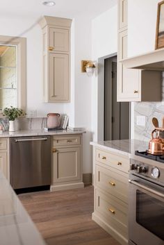 a kitchen with beige cabinets and stainless steel appliances