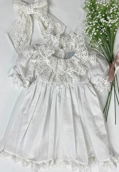 Petite Maison Kids. Made in Turkey. Charming white linen and embroidered lace dress with a large tie bow in the back. Composition: 70% Cotton, 30% Linen. Machine wash. Iron for the best look. Matching Mom version, romper style, and hair accessories available! Off White Lace Dress For Garden Party, Off-white Lace Dress For Garden Party, Elegant Spring Baptism Party Dress, Elegant Floral Embroidery Lace Dress For Summer, Elegant Summer Lace Dress With Floral Embroidery, Elegant Spring Baptism Dress With Lace Collar, Elegant Baptism Dress For Spring, White Lace Dress For Baptism In Spring, White Lace Dress For Spring Baptism