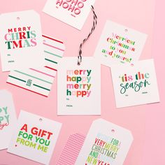 various christmas gift tags on a pink background