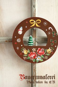 a wooden christmas ornament hanging on a door with a bow and snowman