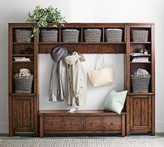 a coat rack with baskets and hats on it next to a wall filled with books