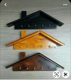 three wooden shelfs with hooks on the top and bottom, one has a coat hanger attached to it