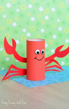 a toilet paper roll with a crab on it sitting on top of a wooden table