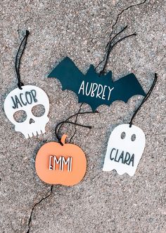 three halloween decorations on the ground with name tags