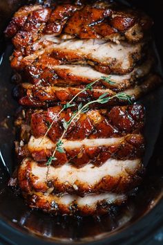 sliced pork in a slow cooker with herbs