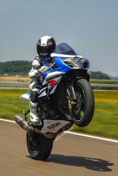 a man riding on the back of a blue motorcycle