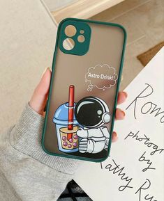 a person holding up a phone case with an astronaut drink on it