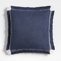 a blue pillow with fringe trim on the front and back of it, against a white background