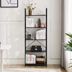 a book shelf with books and other items on it in a white living room next to a window