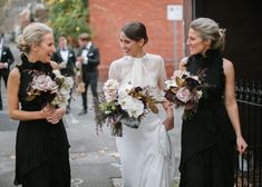 three bridesmaids are walking down the street with their bouquets in each hand