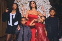 the family poses for a photo in front of a christmas tree