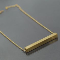 This simple brass necklace is made from brass colored chain and square brass tubing that I found at a salvage yard. The brass bar has been cut to 3" long, and a little over a 1/4" wide. I sanded the pendant to give it a brushed finish. You can select the length of the necklace from the drop box at the right side of the top of this page. The necklace has a gold plated hook and eye style clasp. This necklace is made to order, so it will vary slightly from the one pictured. The necklace is also ava Gold Minimalist Rectangular Bar Necklace, Minimalist Gold Rectangular Bar Necklace, Gold Rectangular Minimalist Bar Necklace, Minimalist Brass Necklace With Rectangular Pendant, Classic Gold Rectangular Bar Necklace, Handmade Rectangular Brass Necklace, Minimalist Yellow Gold Bar Necklace With Rectangular Pendant, Brass Tube, Tube Necklace