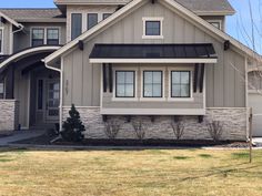 a large house with two story windows and stone sidings on the front of it